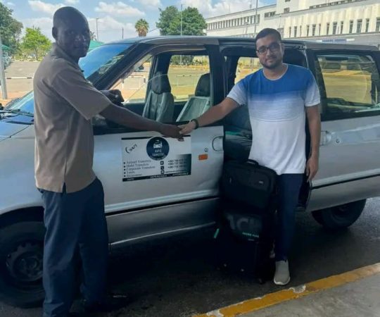 Professional chauffeur opening door for client by luxury vehicle